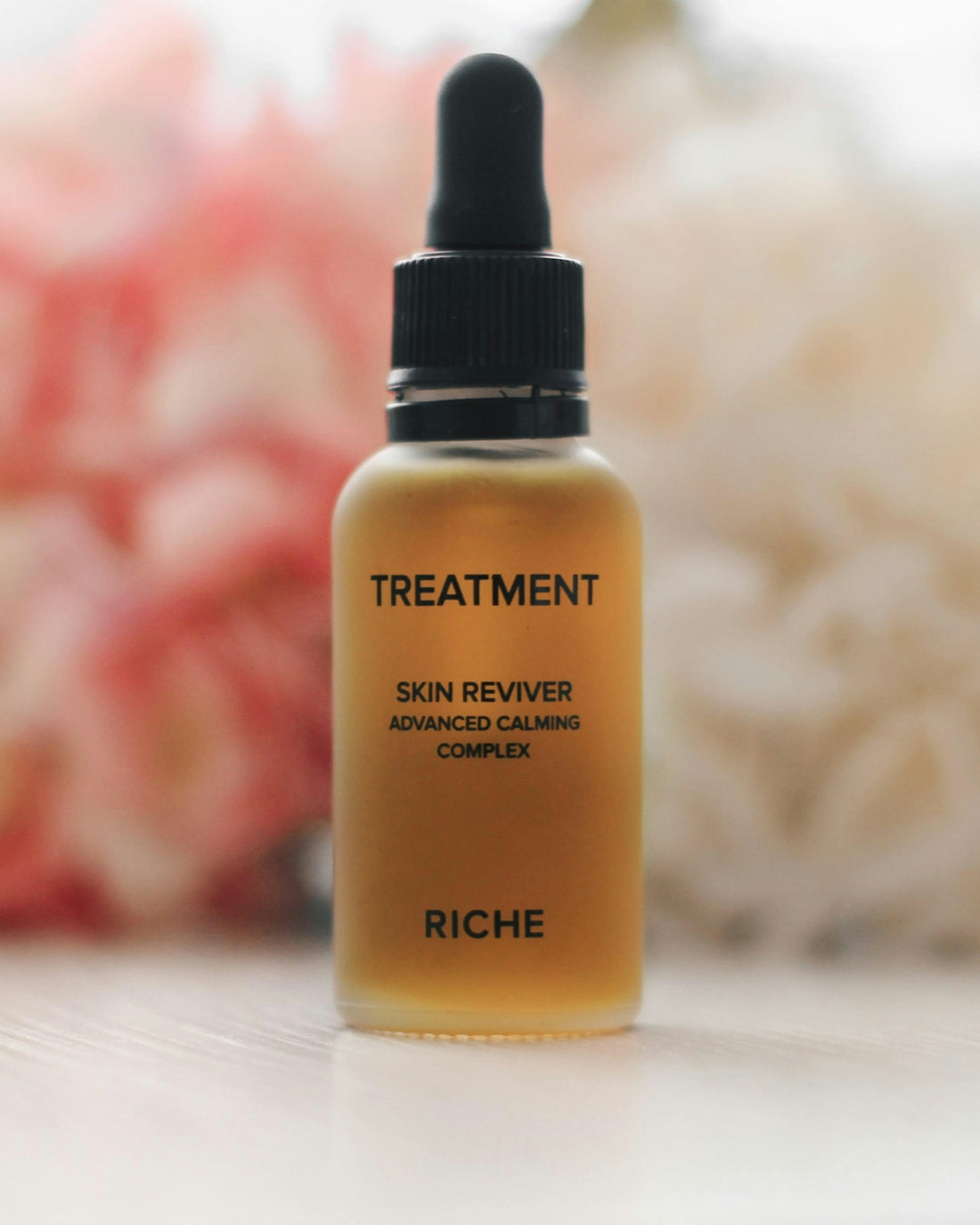 Glass bottle of skin treatment serum with dropper.